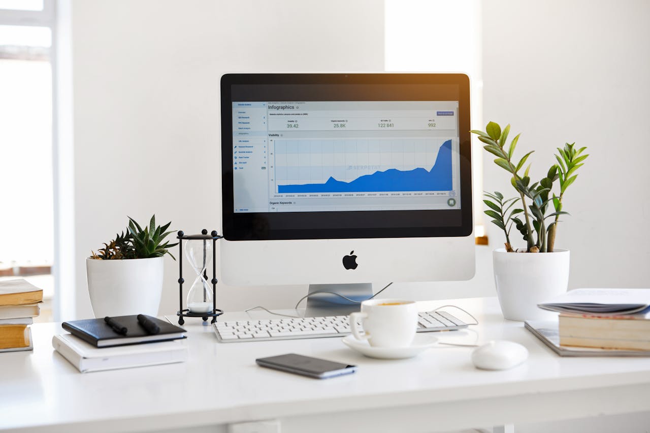 Mastering the First Impression: Your intriguing post title goes here A clean, contemporary workspace featuring a desktop with analytics on the screen and plants for a fresh look.